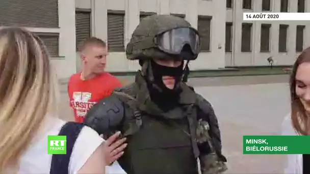 Des jeunes filles étreignent un policier qui a posé son bouclier lors d'une manifestation à Minsk