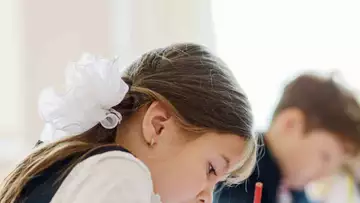 Una niña pequeña da su paga a su profesor que estaba de luto
