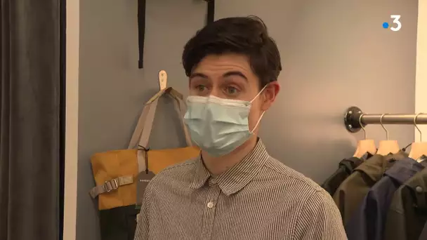 Pierre, commerçant à Rennes explique les gestes barrières dans sa boutique de vêtements