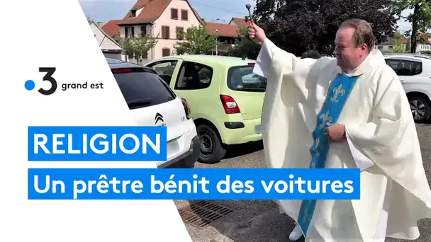 Un prêtre bénit des voitures pour en protéger les conducteurs
