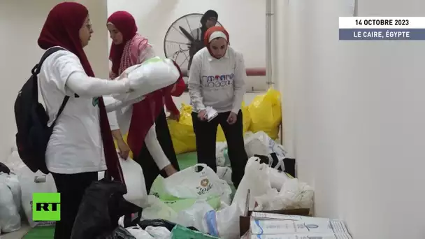 Des dizaines de personnes se rassemblent dans un centre de collecte de dons pour acheminer de l'aide