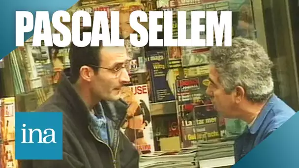 Pascal Sellem vend des journaux devant un kiosque | Archive INA