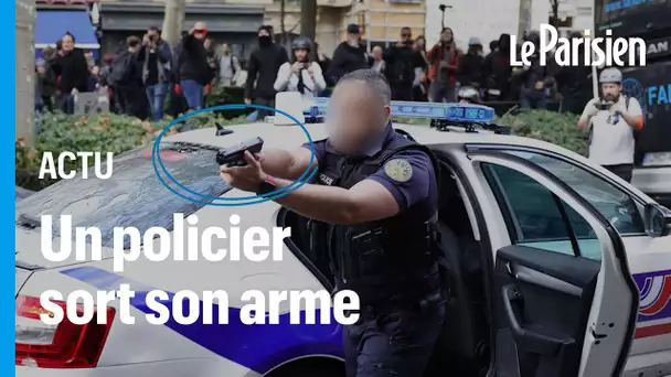 Paris : visé par des projectiles, un policier braque son arme sur des manifestants