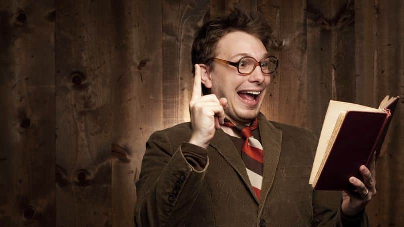 Nerdy man in brown with glasses and book having idea.